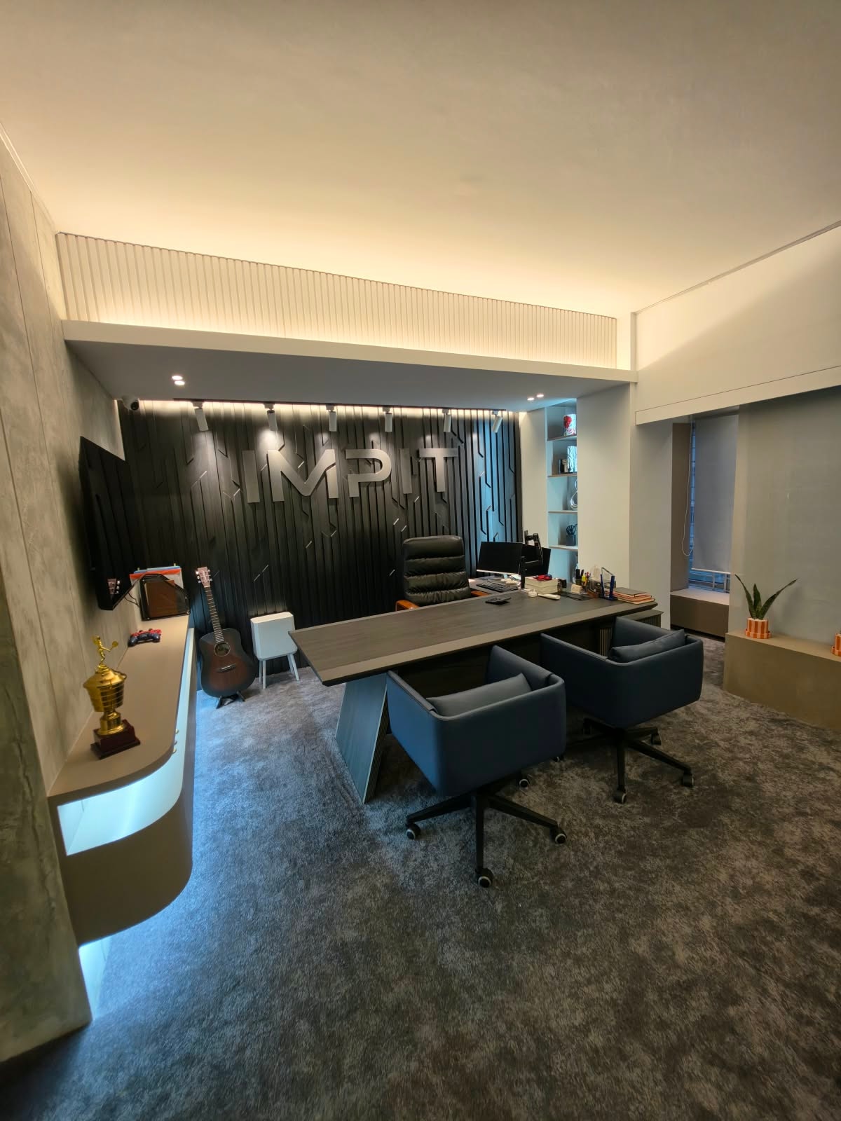 IMPIT executive room with the illuminated IMPIT logo wall